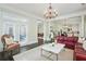 Cozy living room features an elegant chandelier and provides seamless access to the outdoor patio at 200 Edinburgh Ln, Woodstock, GA 30188