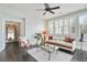 Comfortable living room with ceiling fan, large windows, and a glass coffee table at 200 Edinburgh Ln, Woodstock, GA 30188
