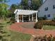 Brick walkway leads to a pergola surrounded by manicured landscaping at 200 Edinburgh Ln, Woodstock, GA 30188