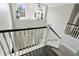 View from the top of a well-lit staircase with white railings and a door visible at the bottom at 200 Edinburgh Ln, Woodstock, GA 30188