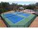 Aerial view of two fenced tennis courts surrounded by trees at 200 Edinburgh Ln, Woodstock, GA 30188