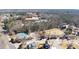 Aerial neighborhood view featuring a traditional brick home, tennis courts, and scenic pond at 1105 Fountain Head Ln, Lawrenceville, GA 30043
