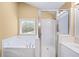 Bright bathroom featuring a bathtub, glass shower, and a window with blind at 1105 Fountain Head Ln, Lawrenceville, GA 30043