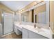 Bathroom featuring a double vanity, large mirror and glass-enclosed shower at 1105 Fountain Head Ln, Lawrenceville, GA 30043