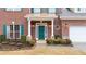 Inviting brick home featuring a teal front door, charming shutters and manicured landscaping at 1105 Fountain Head Ln, Lawrenceville, GA 30043