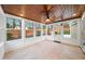 Bright sunroom with wood ceiling, tile floor, ceiling fan, and large windows overlooking backyard at 1105 Fountain Head Ln, Lawrenceville, GA 30043