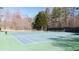Outdoor tennis courts with lighting, set amongst wooded surroundings at Fountain Lakes at 1105 Fountain Head Ln, Lawrenceville, GA 30043