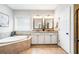 Bright bathroom features a soaking tub, double sinks, and tile flooring at 3557 Ashcroft Se Dr, Smyrna, GA 30080