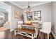 The dining room features a modern chandelier, a wooden table with a bench, and white upholstered chairs at 3557 Ashcroft Se Dr, Smyrna, GA 30080