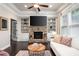 Inviting living room with a stone fireplace, custom built-ins, and large windows providing natural light at 3557 Ashcroft Se Dr, Smyrna, GA 30080