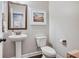 Elegant powder room with pedestal sink, framed mirror, and stylish fixtures at 3557 Ashcroft Se Dr, Smyrna, GA 30080