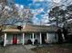 Charming single-story home with gray siding, red door, inviting front porch, and mature trees in a serene neighborhood at 3356 Hollow Ct, Lawrenceville, GA 30044