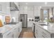 Modern kitchen features stainless steel appliances, white cabinets, subway tile backsplash, and a large island at 3539 Cedarvale Ct, Powder Springs, GA 30127