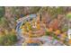 Aerial view of the roundabout entrance and recreation facilities surrounded by lush colorful trees at 583 Carl Sanders Dr, Acworth, GA 30101