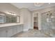 Elegant bathroom featuring marble-lined shower, decorative chandelier, and a large vanity with sleek countertops at 583 Carl Sanders Dr, Acworth, GA 30101
