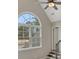 Bedroom with a large window, vaulted ceiling, and a stairway to another level at 583 Carl Sanders Dr, Acworth, GA 30101