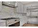 Gourmet kitchen with stainless steel appliances, white cabinetry, and stylish backsplash at 583 Carl Sanders Dr, Acworth, GA 30101