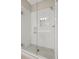 Modern walk-in shower featuring white tiled walls and herringbone-patterned floor at 583 Carl Sanders Dr, Acworth, GA 30101