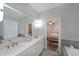 Light-filled bathroom with double vanity, tub and a view into the main bedroom at 1461 Thomas St, Conyers, GA 30094