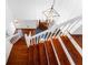 Staircase with white trim and wooden steps, leading to an entryway with a stylish pendant light fixture at 790 Denards Se Ml, Marietta, GA 30067