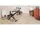 Versatile basement space includes workout equipment and desk area, with wood-look flooring at 1950 Buford Dam Rd # 105, Cumming, GA 30041