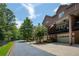 Townhome exterior displaying brick facade, garages, balconies, trees, and community driveway at 1950 Buford Dam Rd # 105, Cumming, GA 30041