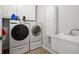 A well-equipped laundry room with modern washer, dryer, and utility sink at 2050 Windermere Xing, Cumming, GA 30041