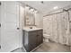 Stylish bathroom features a gray vanity and a shower with a fun patterned curtain at 8007 Wishaw Ct, Winston, GA 30187