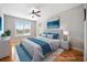 Bright bedroom with hardwood floors, ceiling fan, large window, and calming blue accents at 8007 Wishaw Ct, Winston, GA 30187