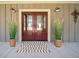 Elegant double front doors flanked by decorative plants and outdoor lighting at 8007 Wishaw Ct, Winston, GA 30187
