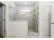 Bright bathroom featuring a shower with glass door and marble-like tiled walls at 110 Jackson St, Buford, GA 30518