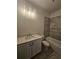 Bathroom featuring gray-tone tiled shower over tub and vanity with light countertops at 110 Jackson St, Buford, GA 30518