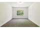 Sunlit room with plush carpeting, white walls, and a view of nature through a window at 110 Jackson St, Buford, GA 30518