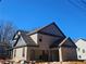 Side view of a brick two-story home with a two-car garage, gray accents, and blue skies at 110 Jackson St, Buford, GA 30518