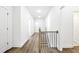 Hallway with wood flooring and natural wood and black metal railing to stairs at 110 Jackson St, Buford, GA 30518