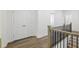 Bright hallway showcases hardwood floors, staircase with wood and iron railing, and double door closet at 110 Jackson St, Buford, GA 30518