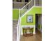 Bright foyer with lime green accent wall, white staircase and wooden floors at 2270 Exchange Se Pl, Conyers, GA 30013