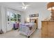 Bright bedroom features a ceiling fan, a large window with a white curtain, and a striped bedspread at 834 Kipling Nw Dr, Atlanta, GA 30318