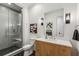 Modern bathroom featuring black and white tile, wood vanity, and a glass-enclosed shower with stylish floral artwork at 1297 Swims Valley Nw Dr, Atlanta, GA 30327