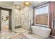 Bright bathroom featuring marble finishes, freestanding tub, and glass shower with seating at 1297 Swims Valley Nw Dr, Atlanta, GA 30327