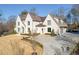 A stately home featuring light brick and mature landscaping has a circular driveway and an attached 3-car garage at 1297 Swims Valley Nw Dr, Atlanta, GA 30327