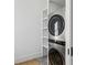 Efficient laundry area with a stacked washer and dryer unit, complemented by built-in shelving at 1297 Swims Valley Nw Dr, Atlanta, GA 30327