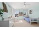 Bright bedroom featuring a ceiling fan, three windows, a white dresser, a desk, and neutral carpet at 3791 Chattahoochee Summit Se Dr, Atlanta, GA 30339