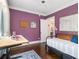Bedroom boasts vibrant purple walls, hardwood floors, and a daybed, offering a cozy retreat at 427 S Columbia Dr, Decatur, GA 30030