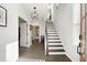 Inviting foyer with hardwood floors, staircase with modern railings, and a stylish light fixture at 6460 Cortland Walk, Alpharetta, GA 30005