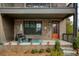 Cozy brick patio with black wicker furniture, a bright blue rug, and an orange front door at 6460 Cortland Walk, Alpharetta, GA 30005