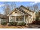 Charming two-story yellow home with a welcoming front porch and mature landscaping in a walkable neighborhood at 873 Monroe Ne Cir, Atlanta, GA 30308