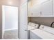 Well-lit laundry room featuring a white washer and dryer and matching white cabinets for ample storage at 10 Perimeter Summit Ne Blvd # 3204, Atlanta, GA 30319
