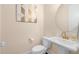 Half bathroom with a pedestal sink, round mirror, and geometric wall decor at 1872 Commons Nw Pl, Atlanta, GA 30318