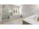 Bathroom featuring marble walk-in shower, soaking tub, double sinks, and white countertops at 1872 Commons Nw Pl, Atlanta, GA 30318
